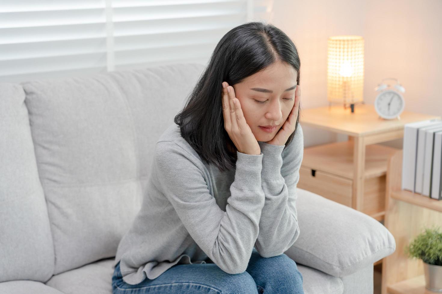 malheureuse femme asiatique fille déçue, triste à cause d'un problème à la maison seule, se sentir seule, stressée, souffrant d'une mauvaise relation, rompre, divorcer, femme confuse, dépression santé mentale, solitude photo