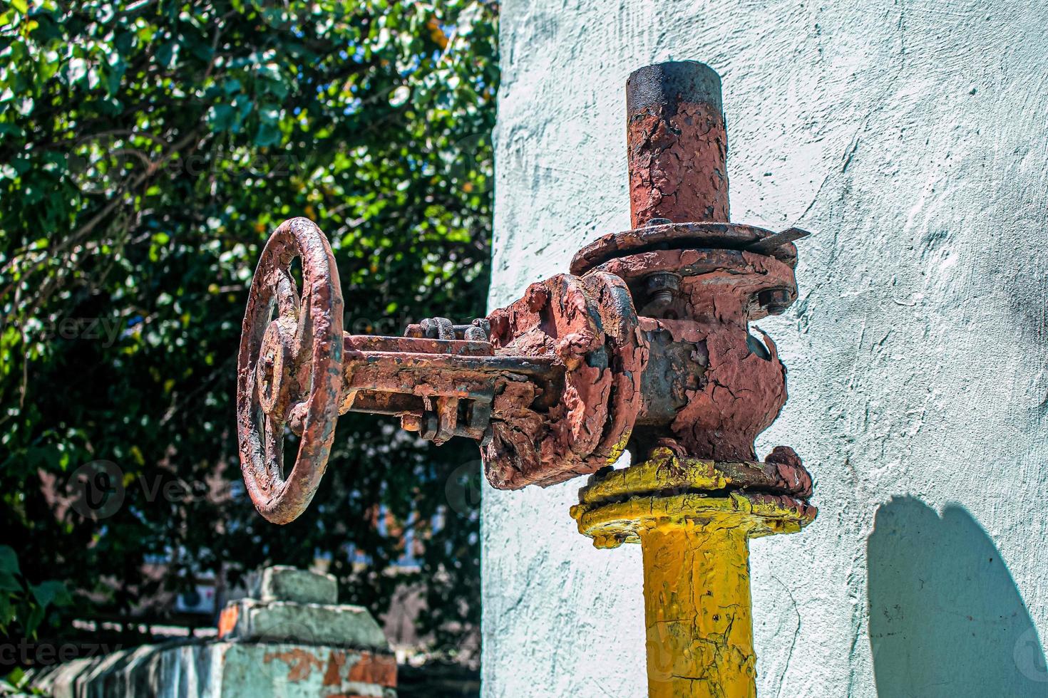 vieux robinet de gaz rouillé sur le fond du mur de la maison. photo