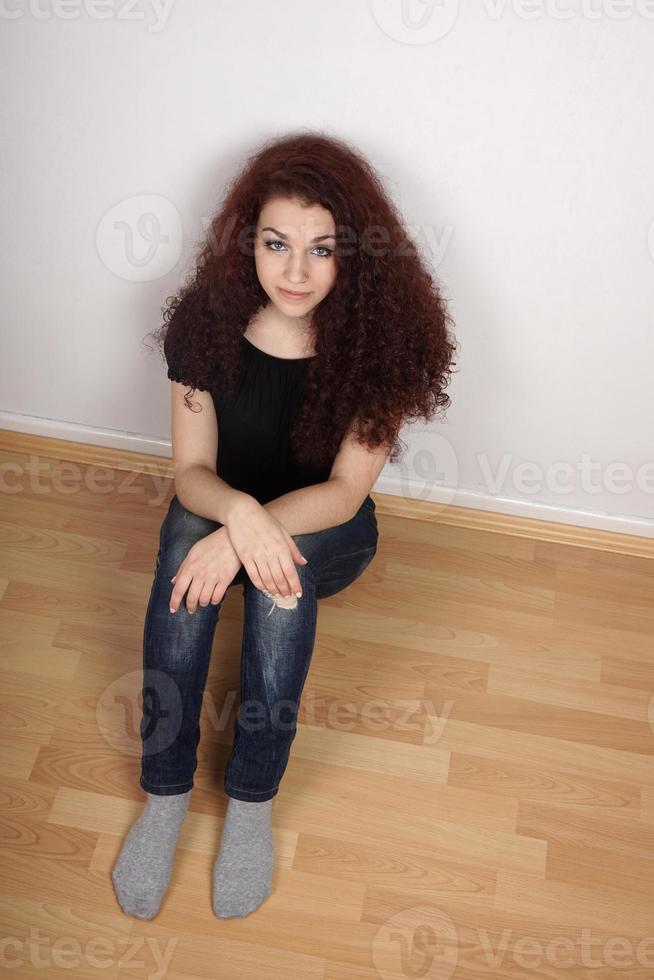 fille assise sur un sol stratifié photo