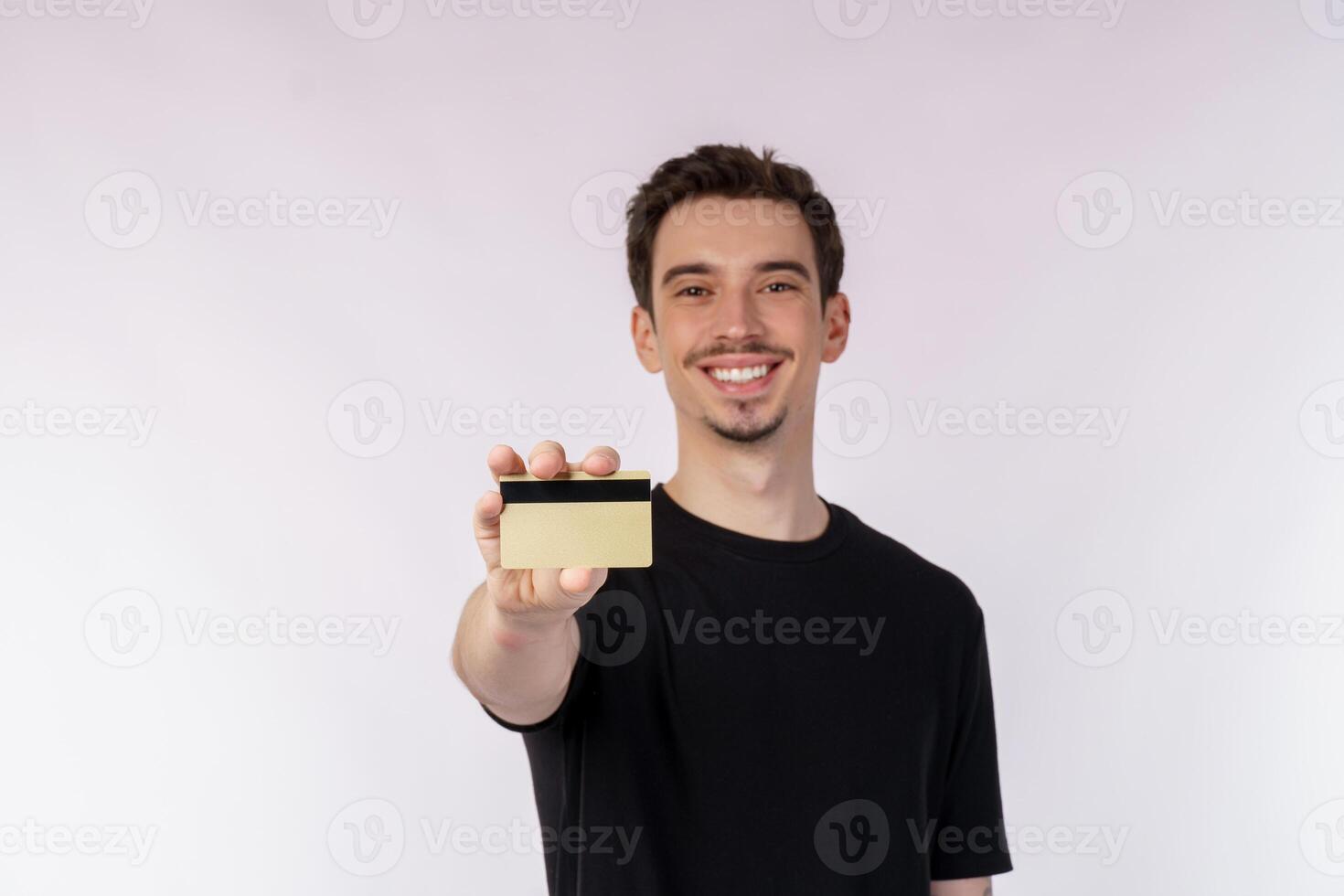 Portrait of young smiling handsome man in casual clothes montrant carte de crédit isolé sur fond blanc photo