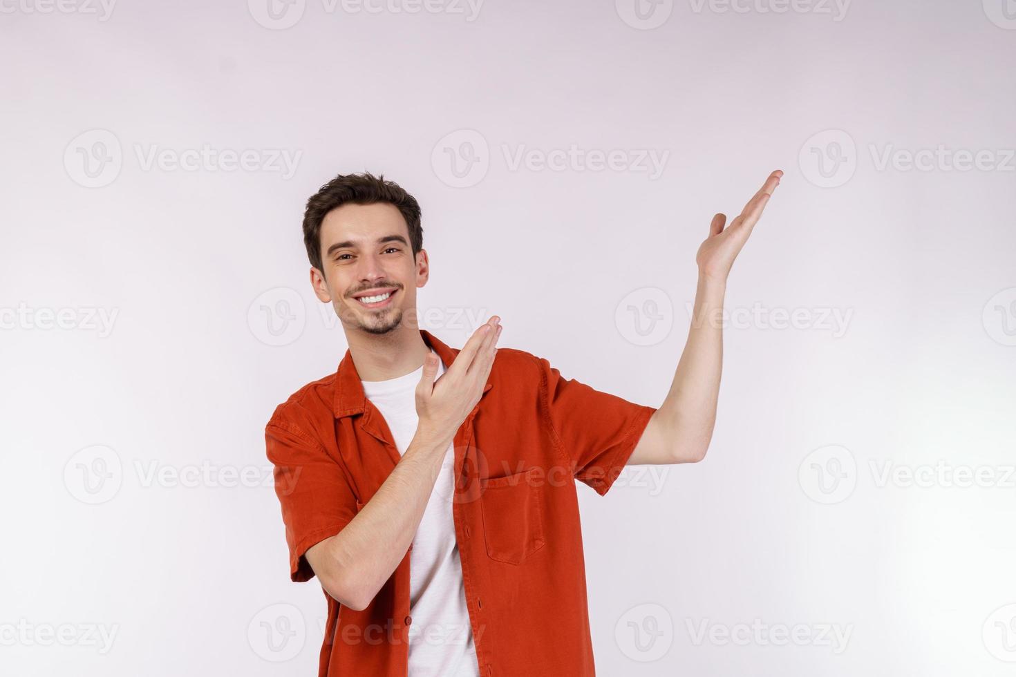 Portrait of happy smiling young man présentant et montrant votre texte ou produit isolé sur fond blanc photo