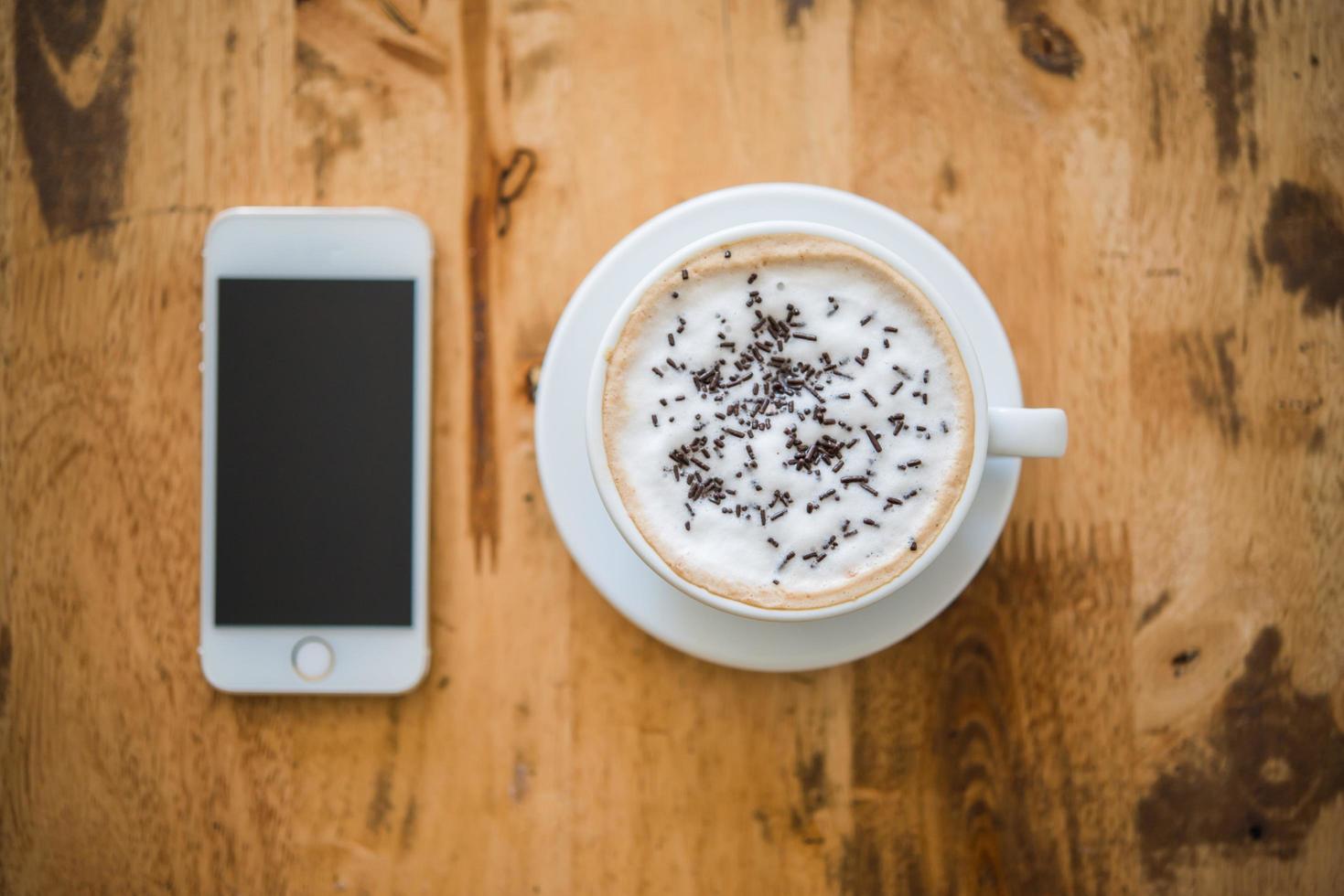Une tasse de café et de smartphone sur une table en bois au café photo