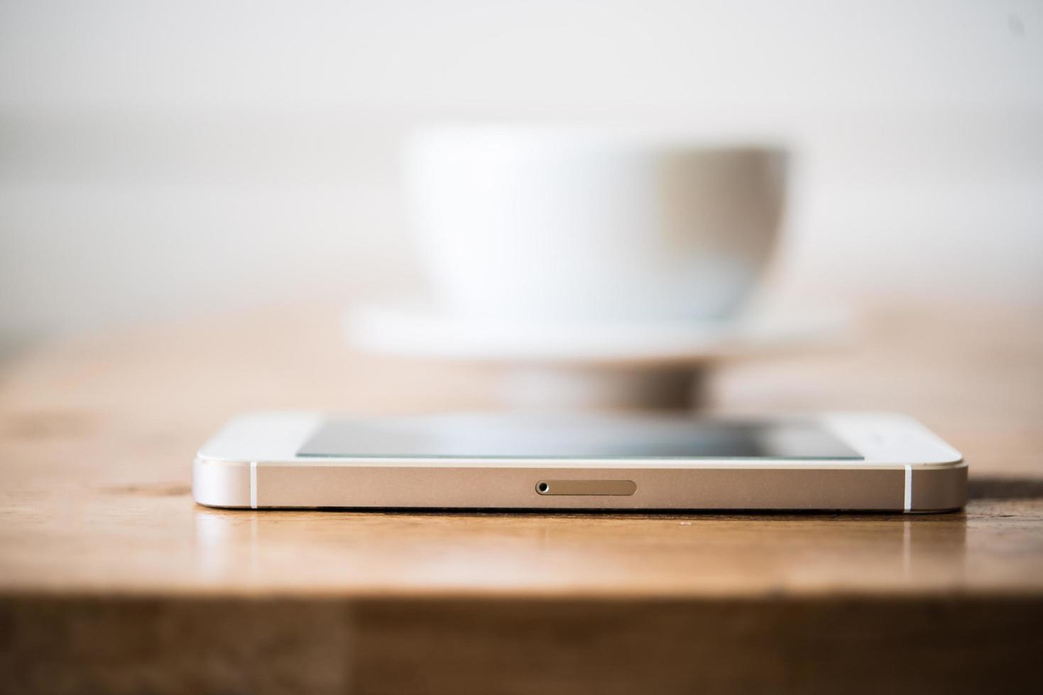 Une tasse de café et de smartphone sur une table en bois au café photo