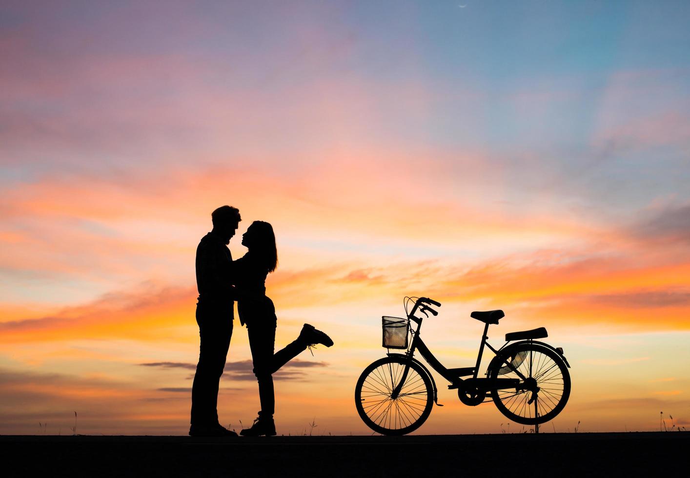 silhouette de jeune couple au coucher du soleil photo