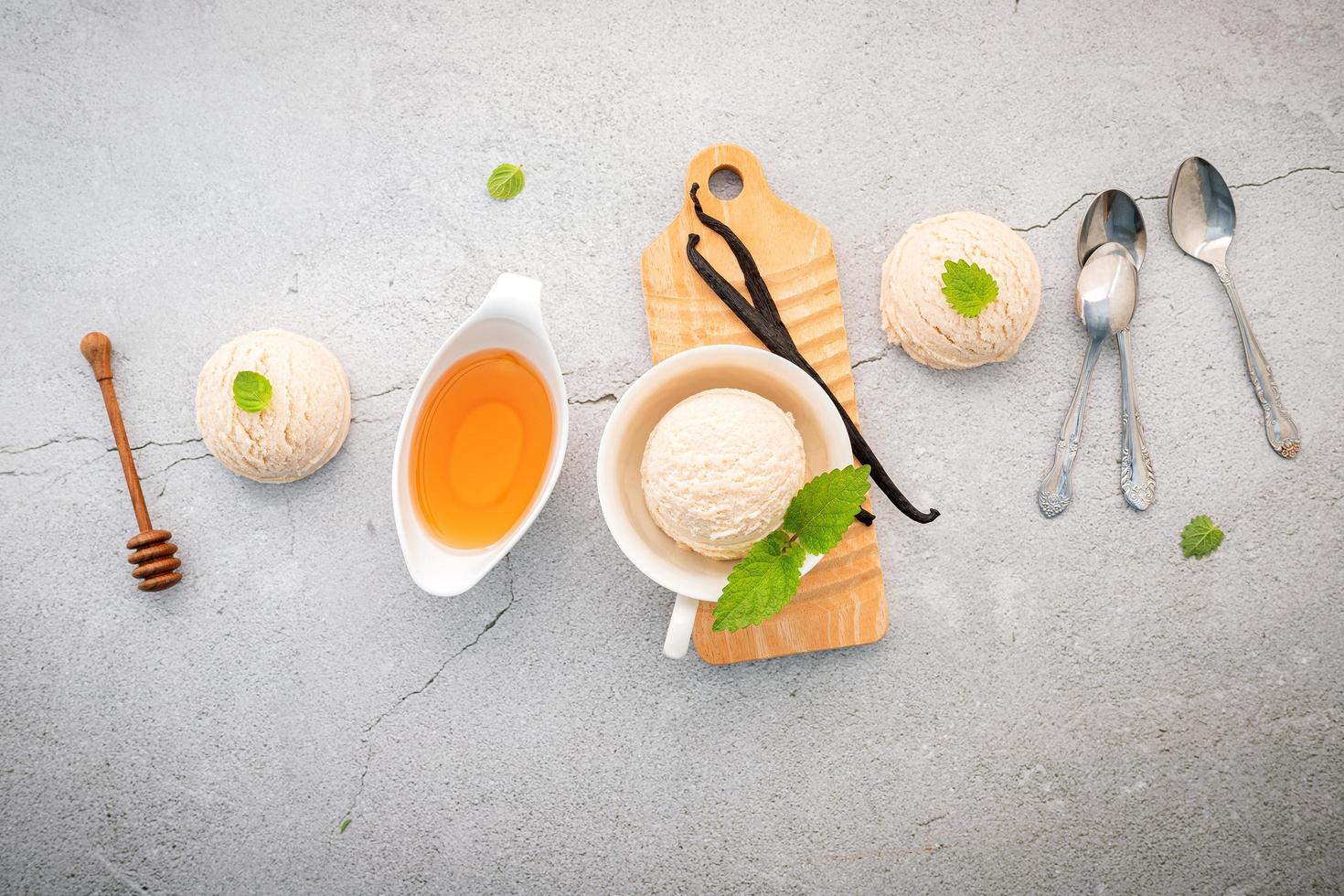 Saveur de crème glacée à la vanille dans un bol avec des gousses de vanille sur fond de béton photo
