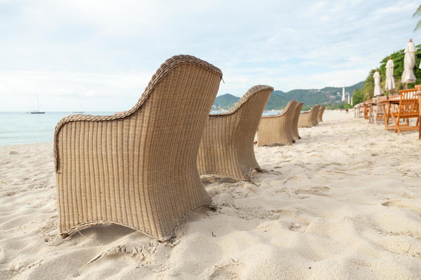 Chaises et tables sur la plage en Thaïlande photo