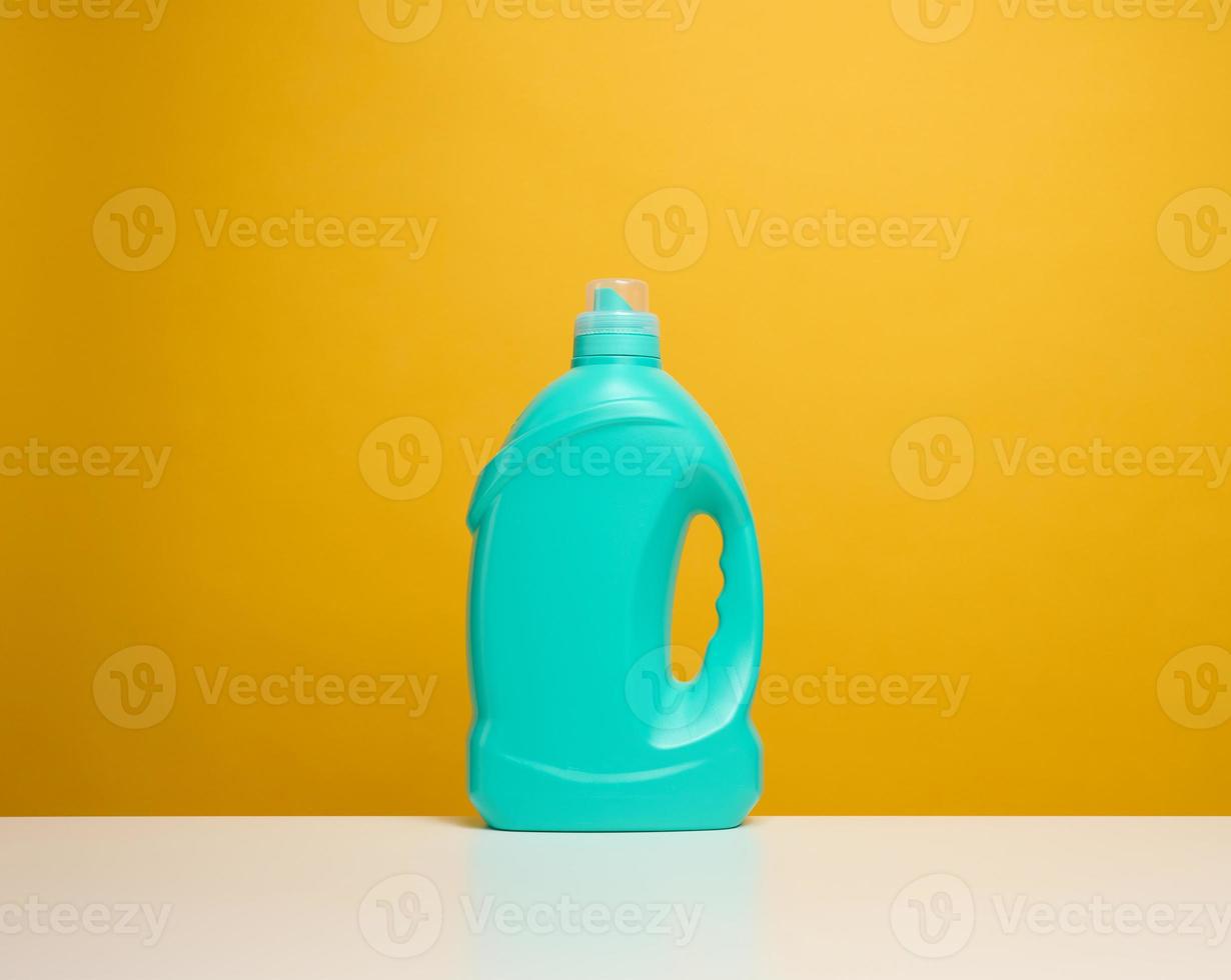 Plastique bleu bouteille avec liquide détergent supporter sur une blanc table photo