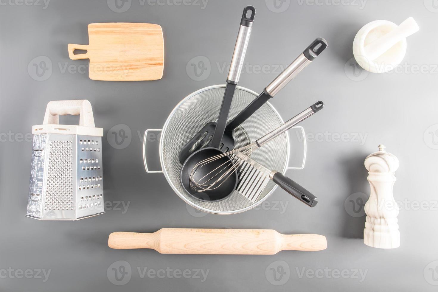 divers cuisine ustensiles fabriqué de bois, métal, céramique sur une gris Contexte. Haut voir. plat poser. photo