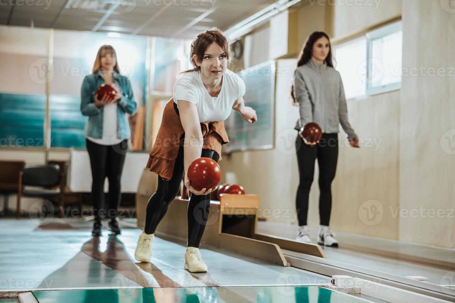 Jeune femme jouant au bowling neuf broches photo