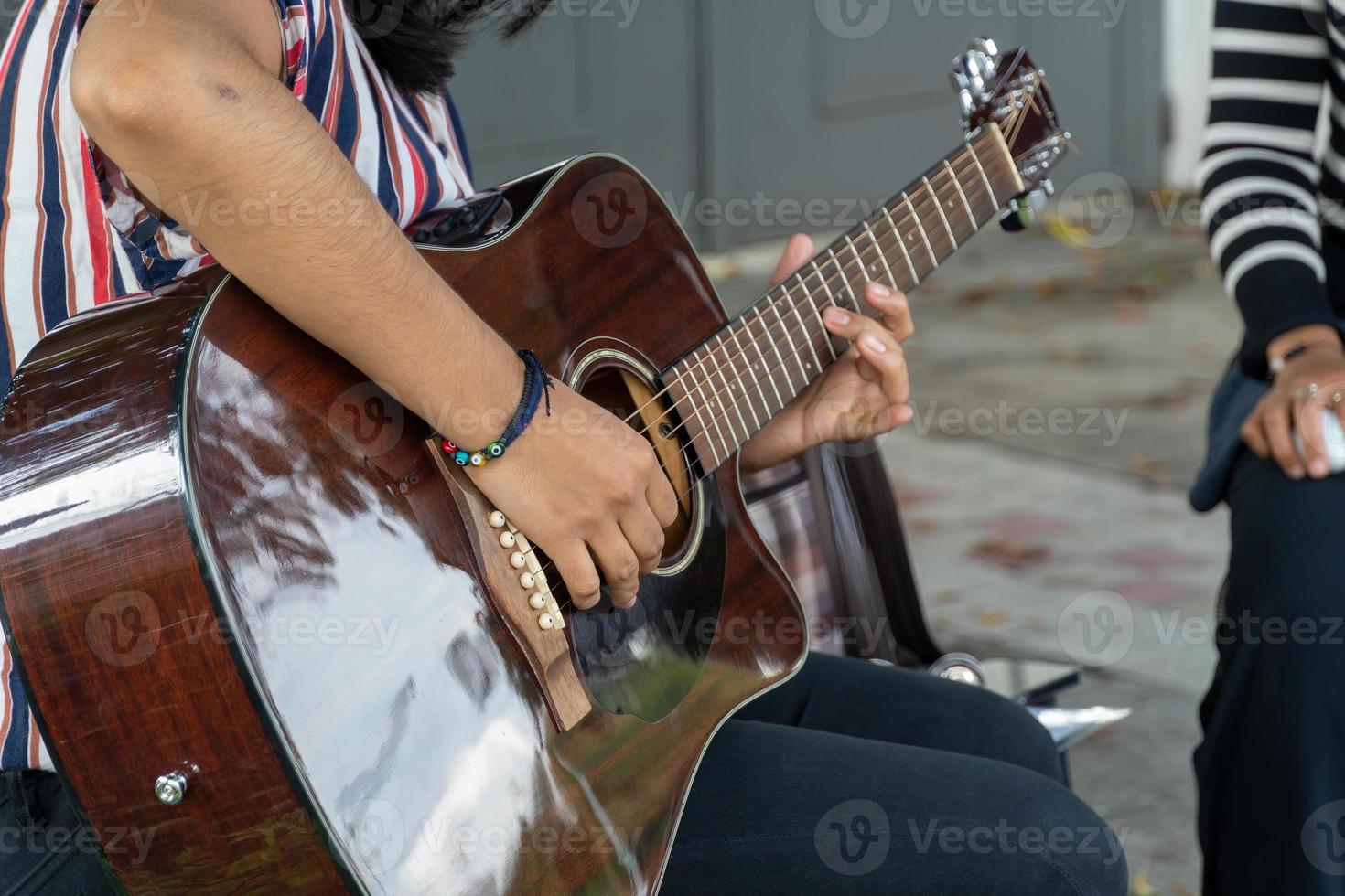 femme latina jouant de la guitare dans la rue, jeune femme brune, amérique latine photo