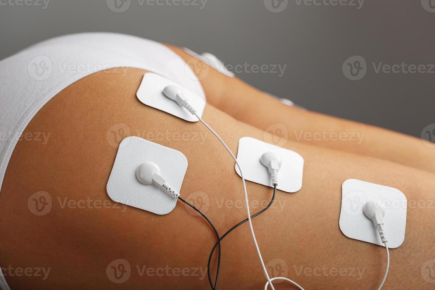 électrodes de myostimulation sur les fesses et les jambes d'une femme dans un salon de beauté. photo