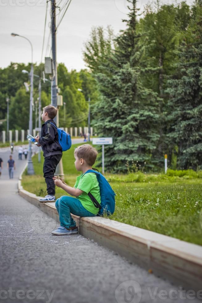 portrait d'un enfant, d'un garçon sur fond de paysages urbains de gratte-ciel et d'immeubles de grande hauteur en plein air. enfants, voyages. mode de vie dans la ville. centre, rues. photo