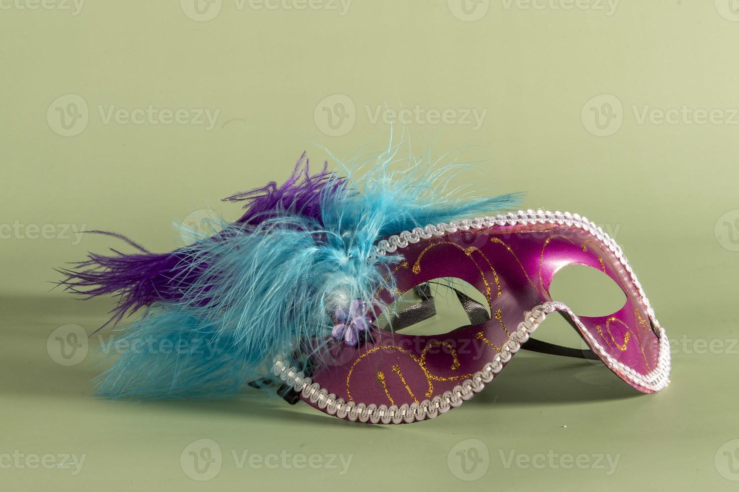masque de carnaval vénitien avec plumes et éléments typiques en arrière-plan photo