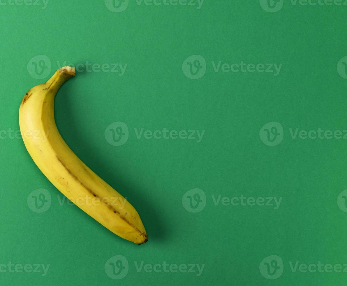 mûr Jaune un banane sur une vert Contexte photo