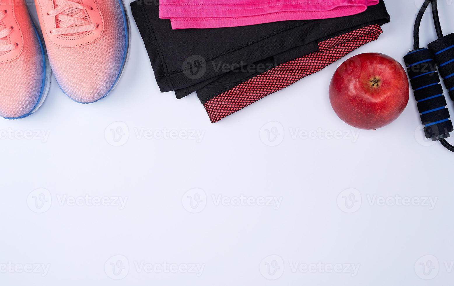 chaussures textiles roses et autres articles de fitness sur fond blanc photo