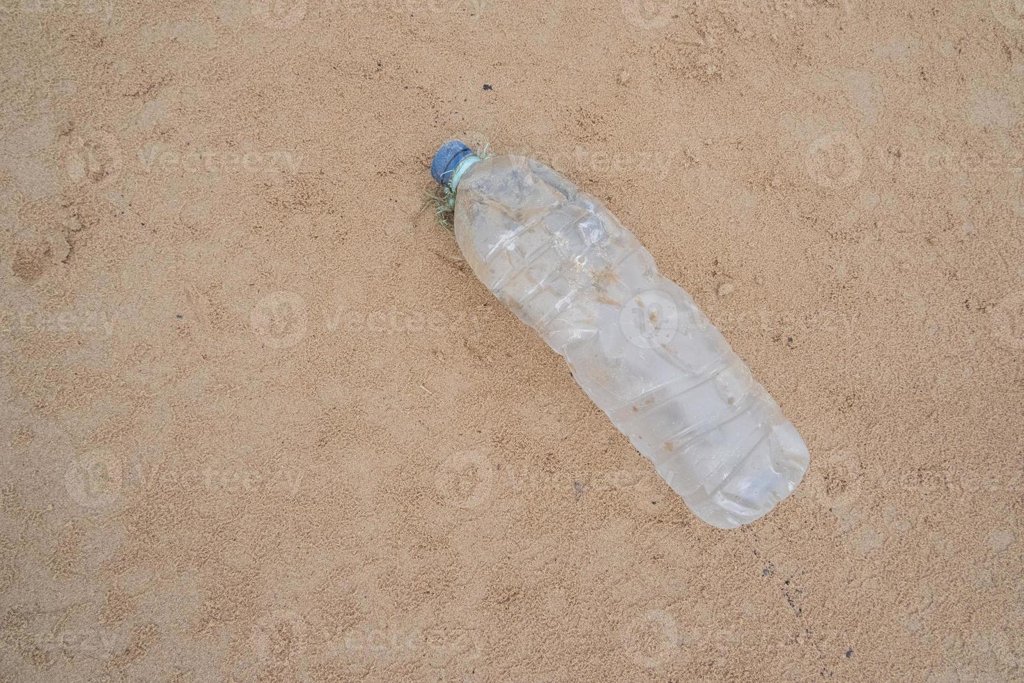 Plastique bouteilles de les boissons sur le plage le sable photo