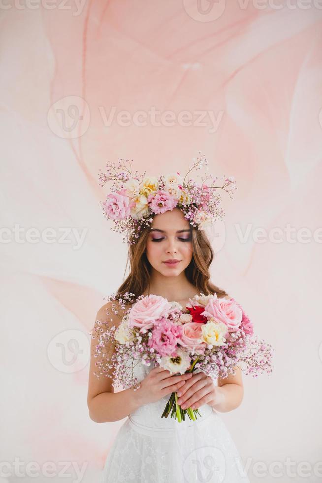 portrait de magnifique la mariée avec fleur couronne sur sa tête et de mariée bouquet photo
