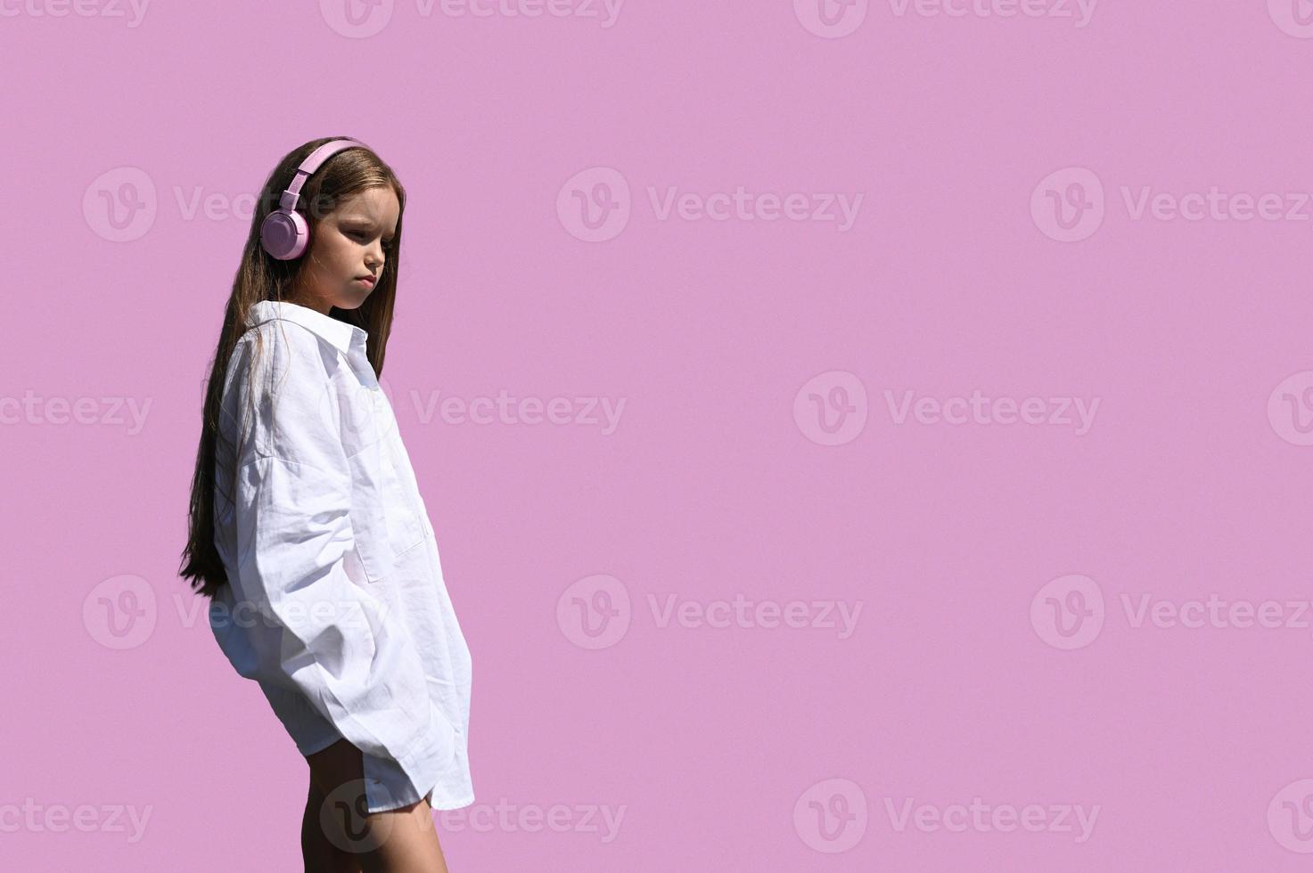 une fille dans une blanc chemise, permanent sur une rose Contexte. conception pour le bannière. photo