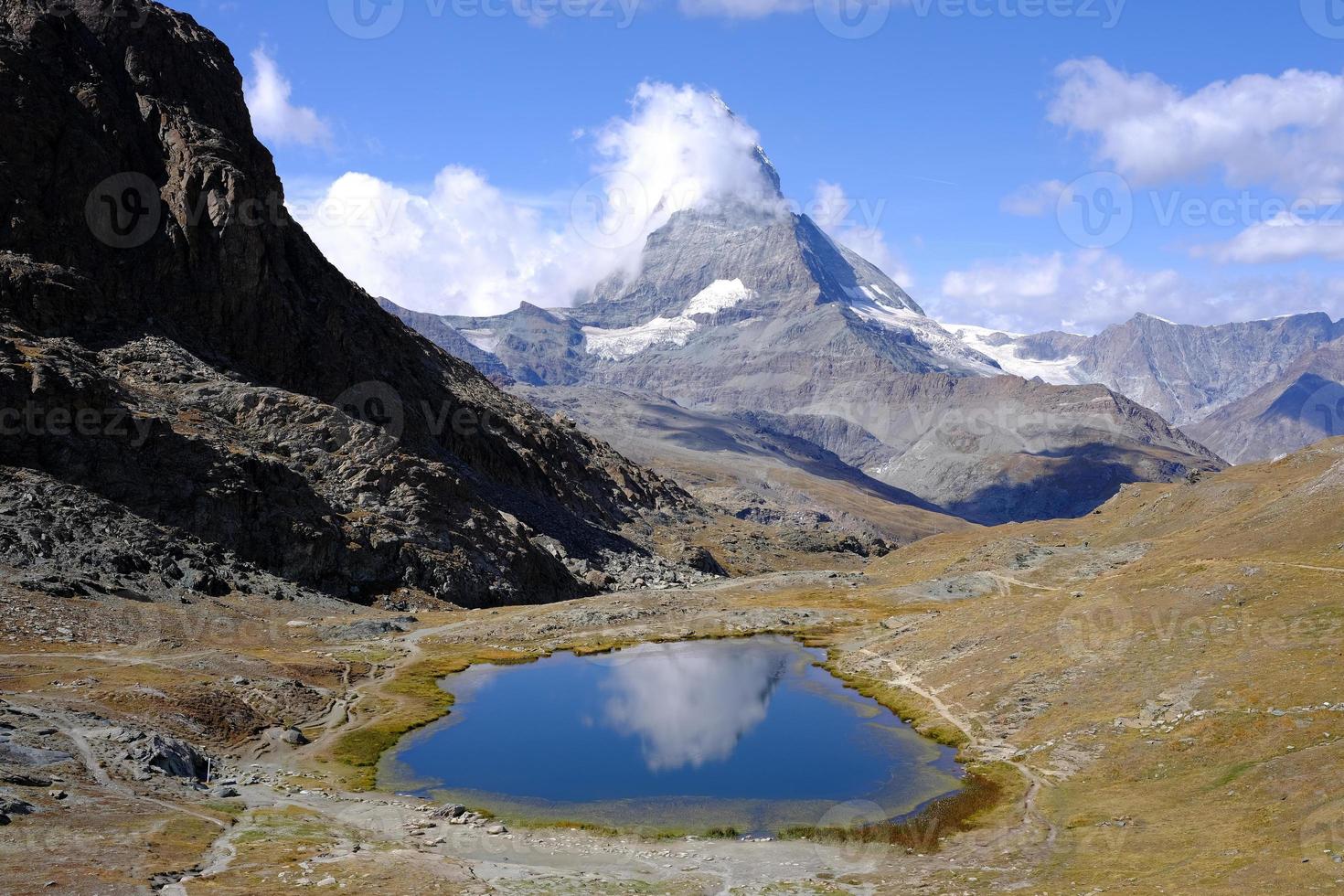 Matterhorn réfléchi sur Riffelsee avec couvert blanc nuage. photo