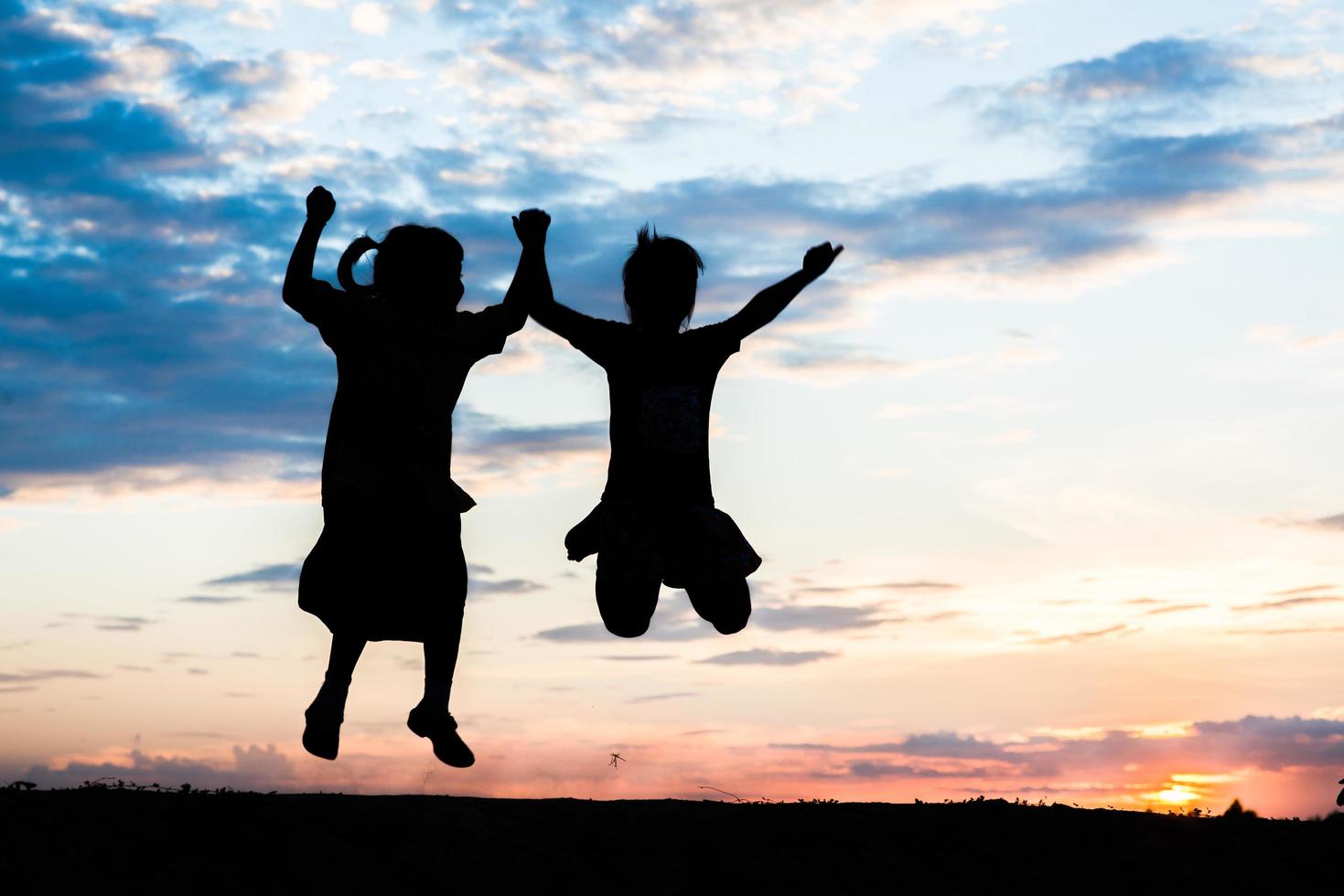 coucher de soleil silhouette d'enfants jouant photo