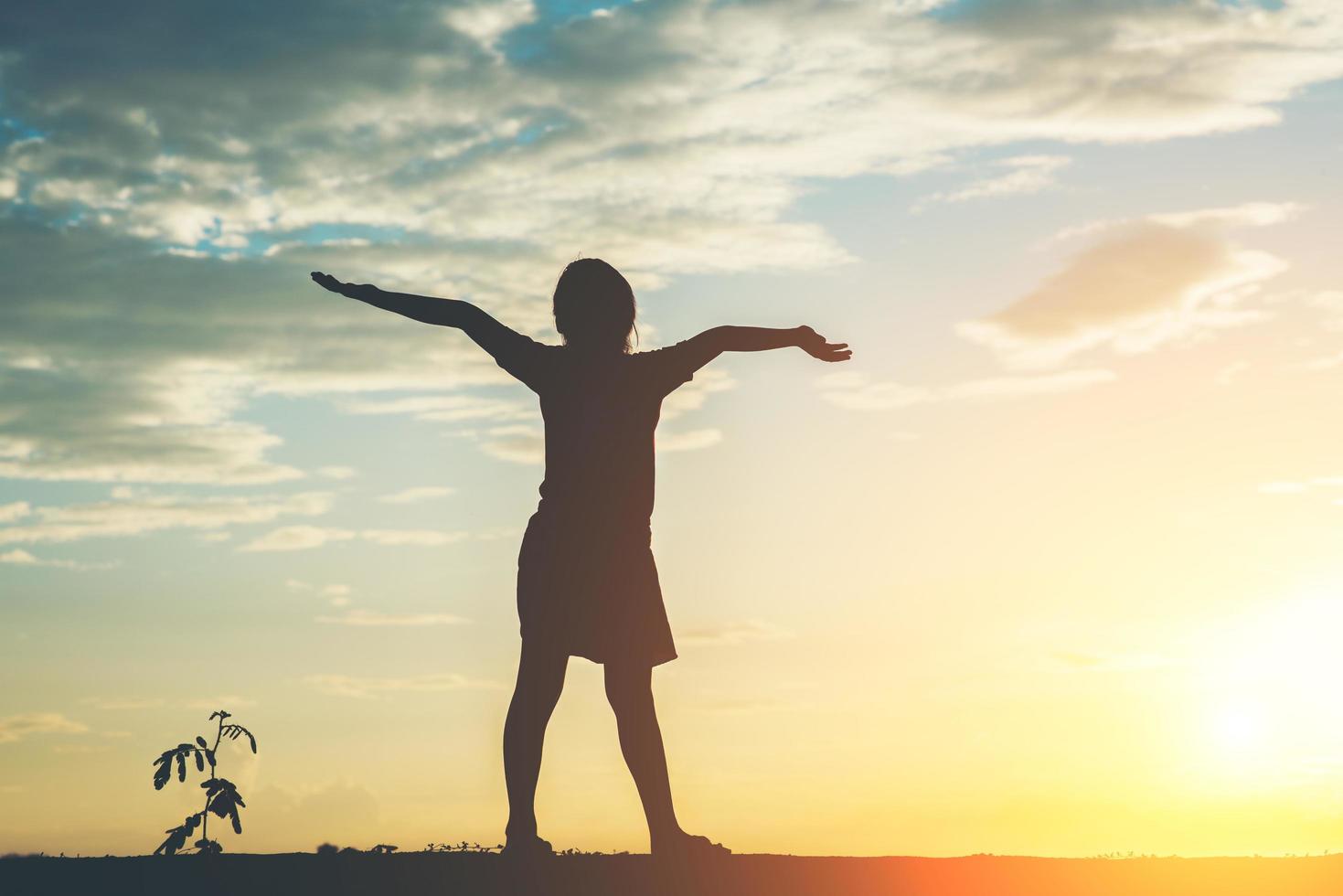 silhouette de petite fille levant les mains pour la liberté photo