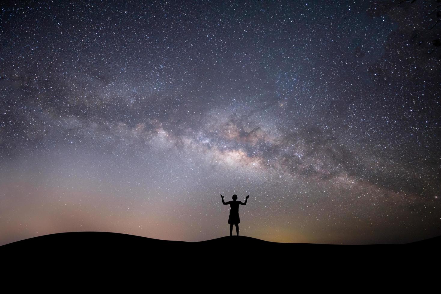 silhouette d'une femme au sommet d'une colline avec des étoiles photo