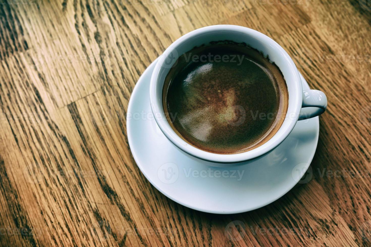 blanc tasse de noir café sur le en bois table dans classique Ton. photo