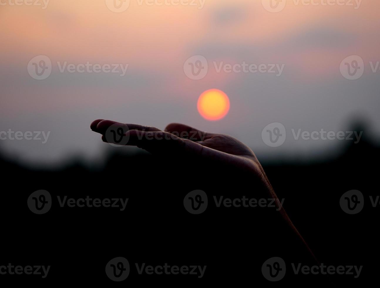 silhouette de Humain main élevé à faire une souhait, le coucher du soleil Contexte photo