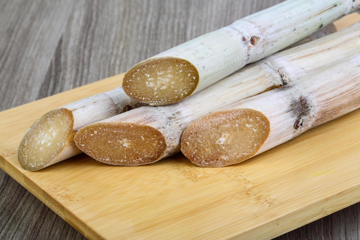 bâtonnets de sucre sur planche de bois et fond en bois photo