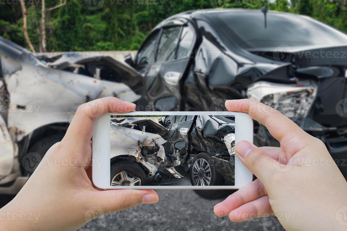 une femme utilisant un smartphone prend une photo d'un accident de voiture sur la route