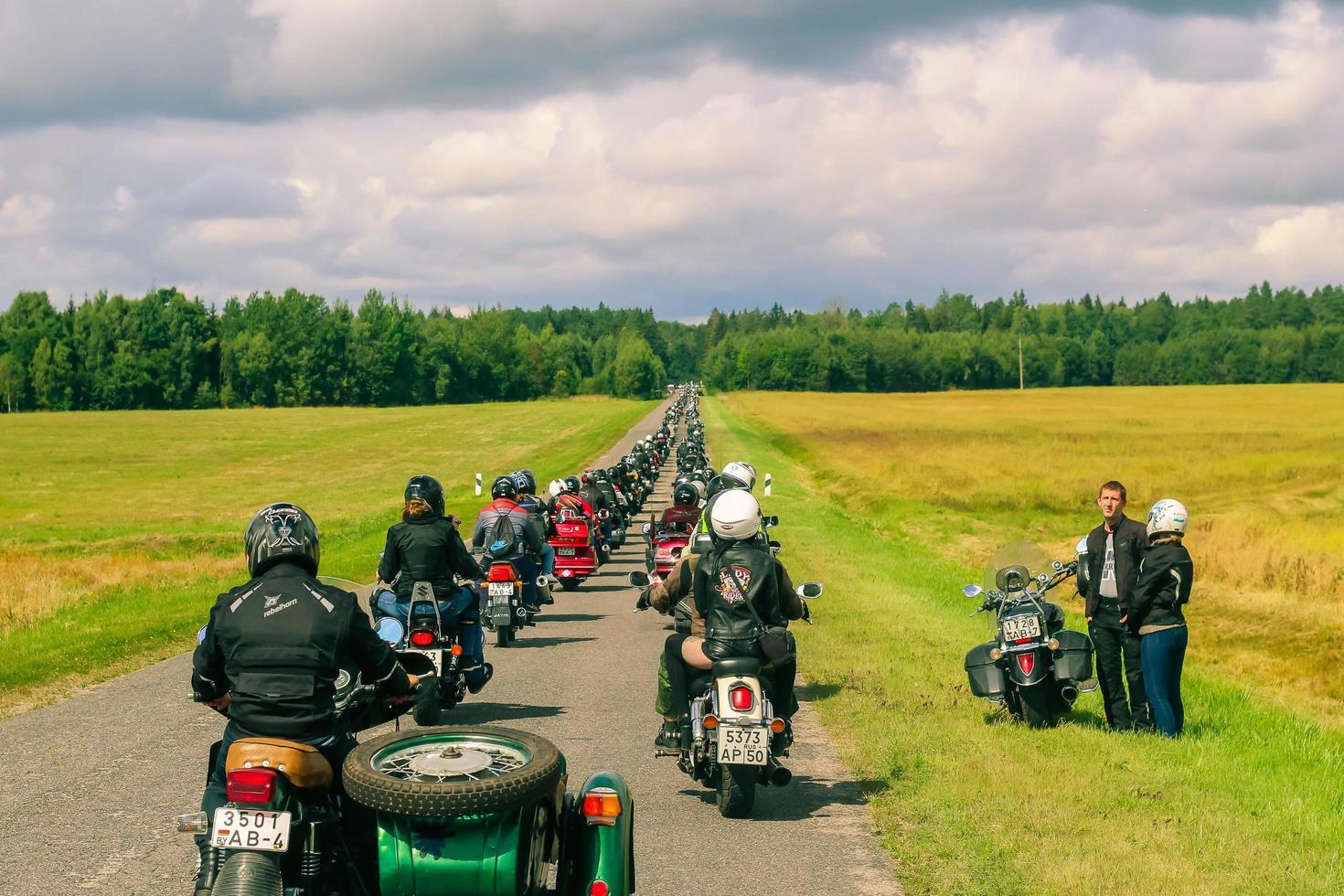 groupe de motocyclistes monte sur asphalte pays route sur été ensoleillé journée. parade de motocyclettes. photo