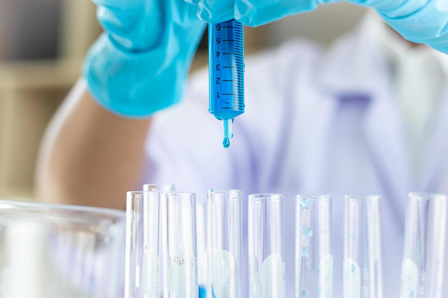 déposer un liquide bleu dans des tubes à essai photo