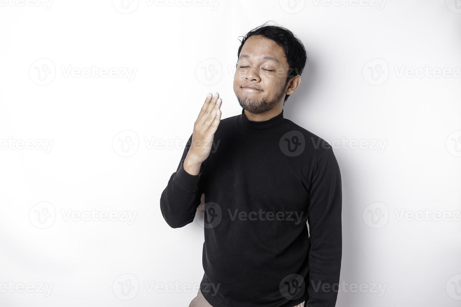 portrait de somnolent attrayant asiatique homme portant une noir chemise, sentiment fatigué après nuit sans pour autant dormir, bâillement, couvrant ouvert bouche avec paume photo