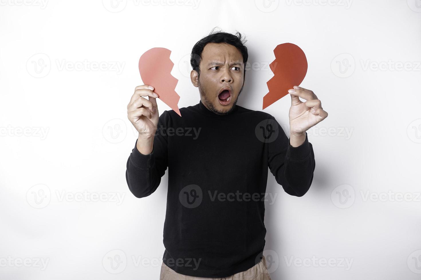 magnifique Jeune asiatique homme exprimé le sien tristesse tandis que en portant cassé cœur isolé sur blanc Contexte photo