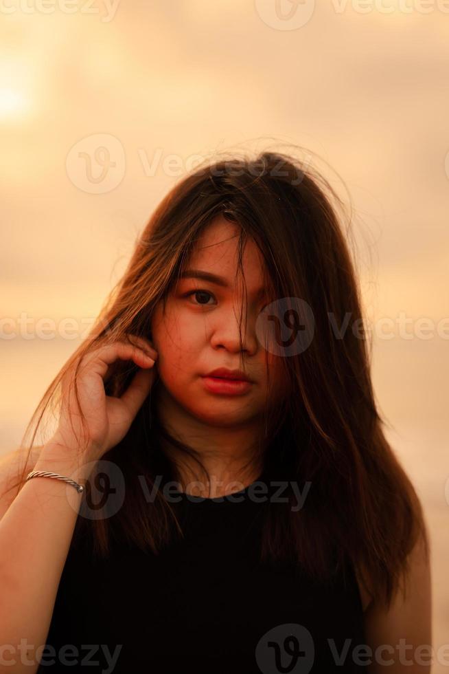 une magnifique et sexy asiatique femme avec une faciale expression cette regards foiré en haut tandis que permanent sur le plage photo