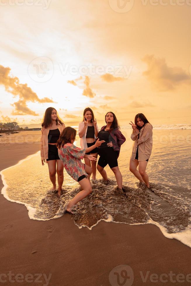 une groupe de indonésien femmes prendre plaisir le plage Heureusement lorsque elles ou ils rencontrer leur copains à le vacances moment photo