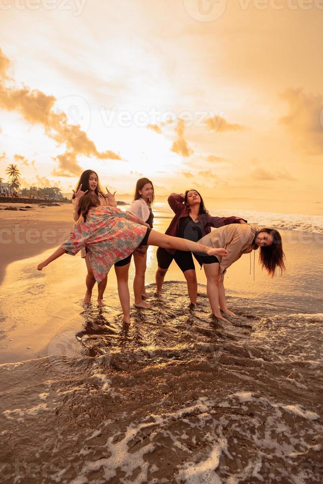une groupe de indonésien femmes prendre plaisir le plage Heureusement lorsque elles ou ils rencontrer leur copains à le vacances moment photo