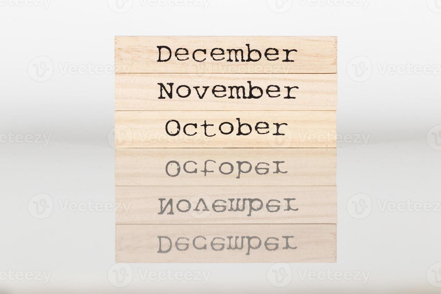 en bois cube avec le une inscription octobre, novembre, décembre sur une blanc Contexte photo