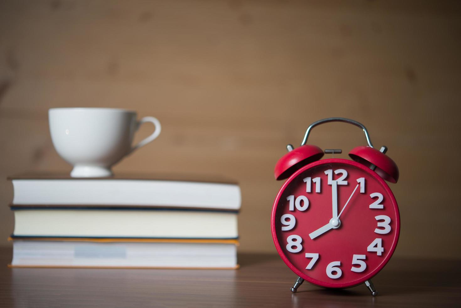 réveil à 8h et pile de livres avec tasse de café photo