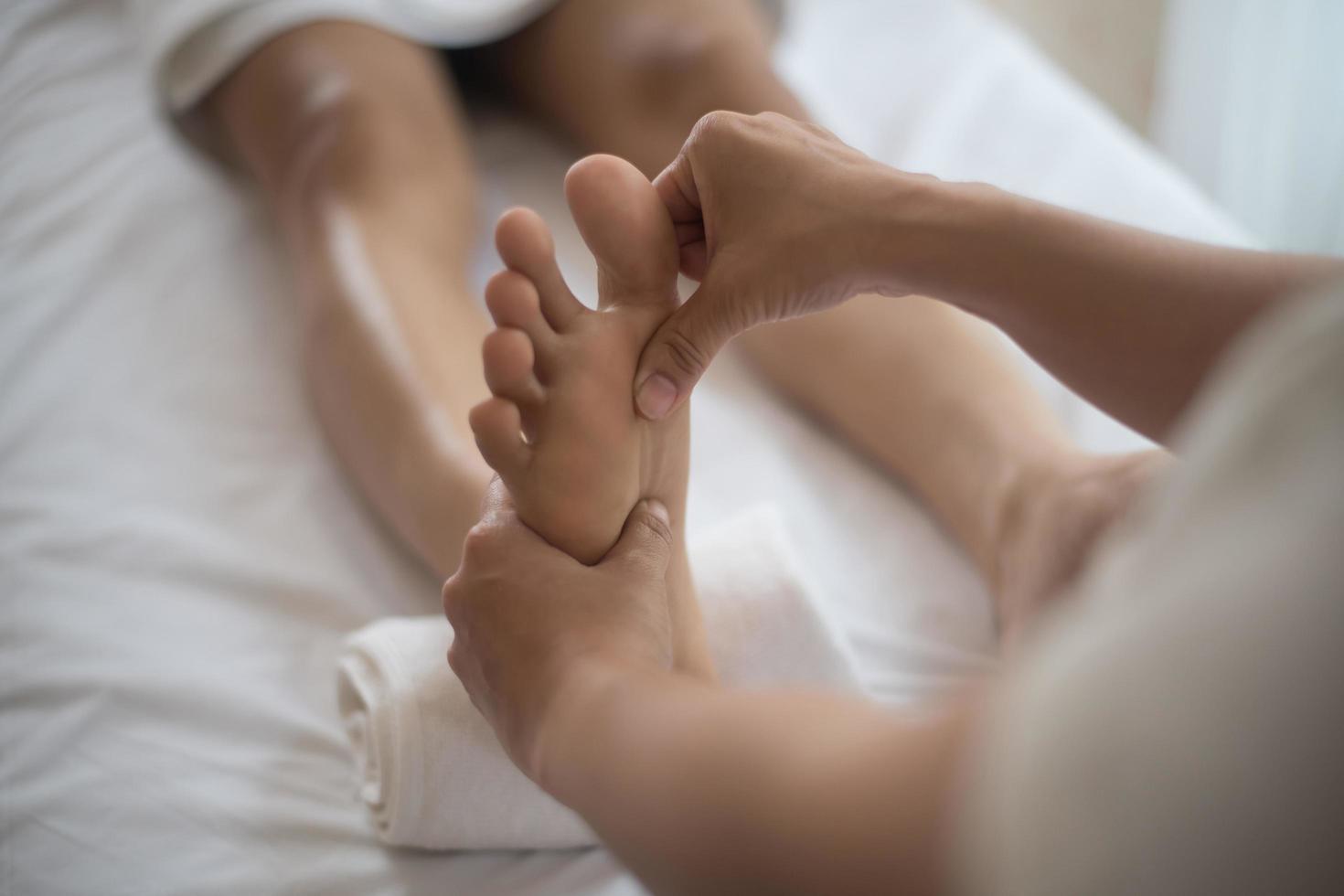 femme ayant un massage des pieds dans un salon de beauté photo