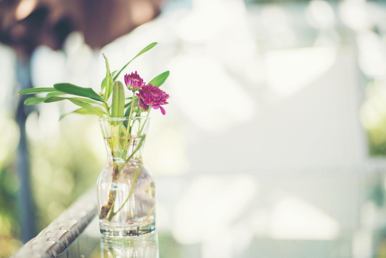 Fleurs violettes dans un vase sur une table à l'extérieur photo