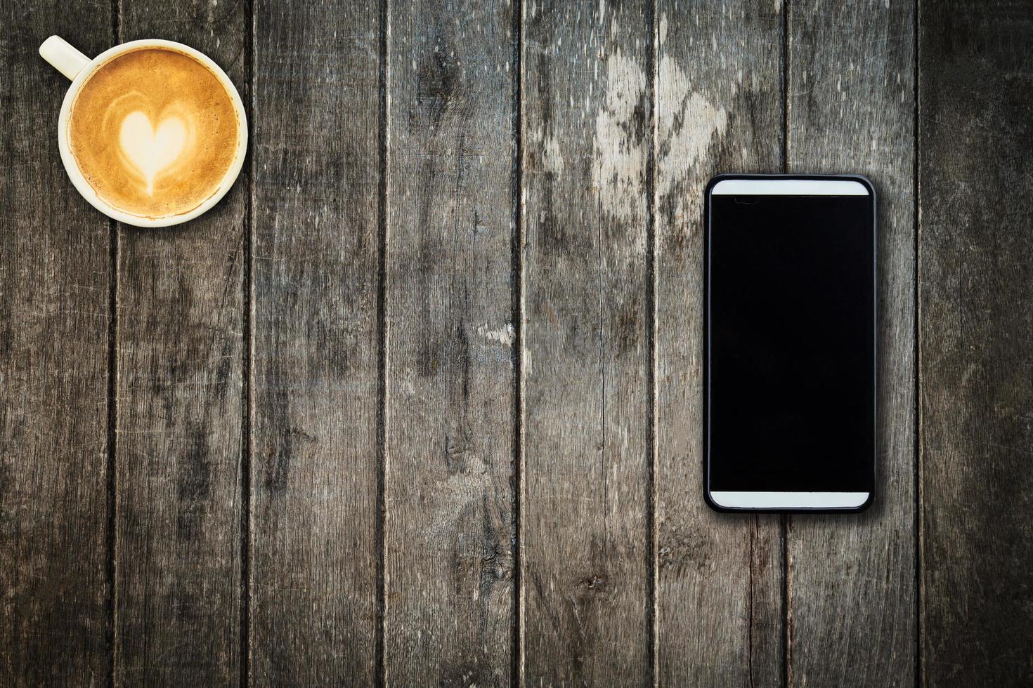 mobile téléphone et café tasse sur Bureau en bois table avec copie espace photo