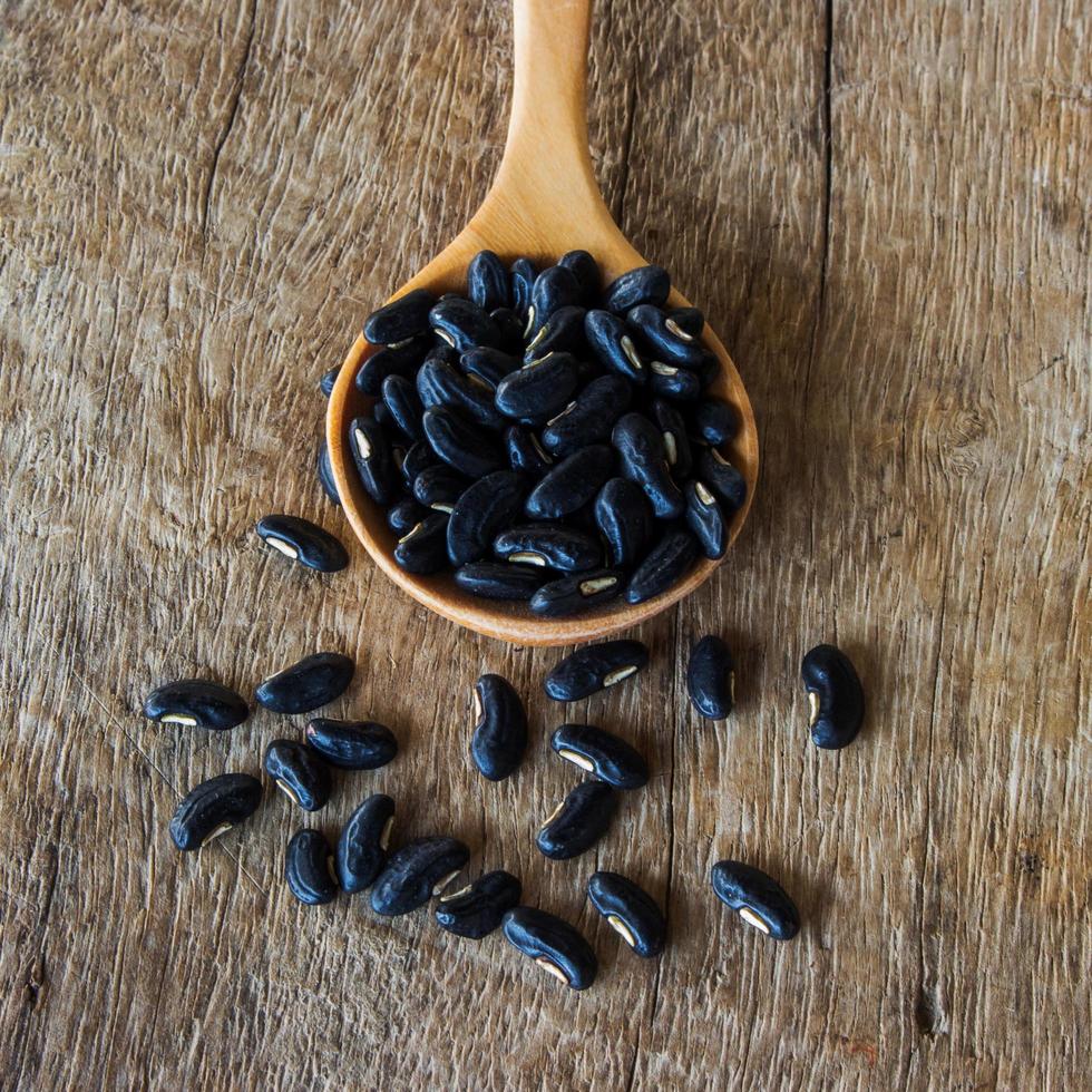 Close up cuillère de graines de haricots sur table en bois photo