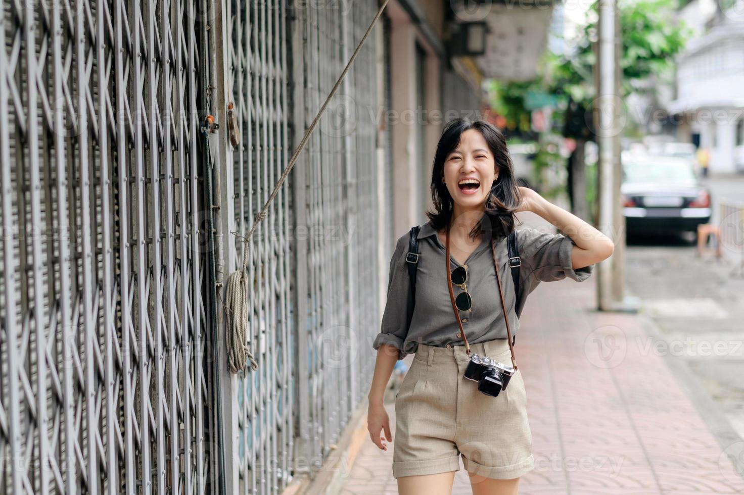 Jeune asiatique femme sac à dos voyageur profiter rue culturel local endroit et sourire. voyageur vérification en dehors côté des rues. photo