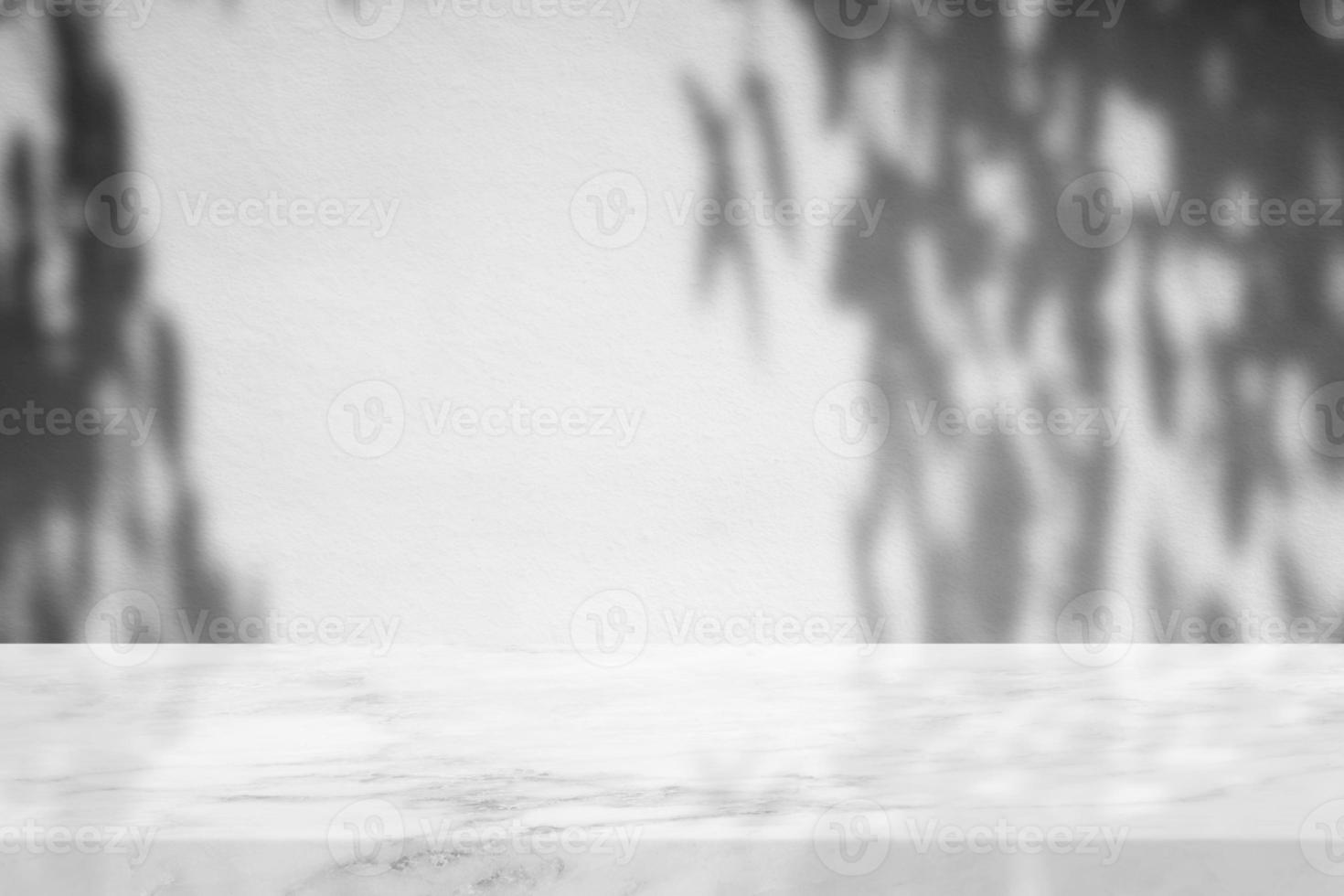 table en marbre blanc avec ombre d'arbre sur fond de texture de mur en béton, adaptée à la toile de fond, à l'affichage et à la maquette de présentation du produit. photo