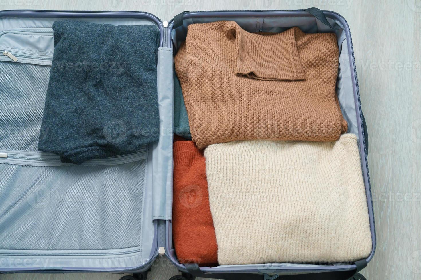 hiver vêtements dans bagage. temps à voyage, voyage, se détendre, printemps ou l'automne ou hiver saison et vacances concepts photo