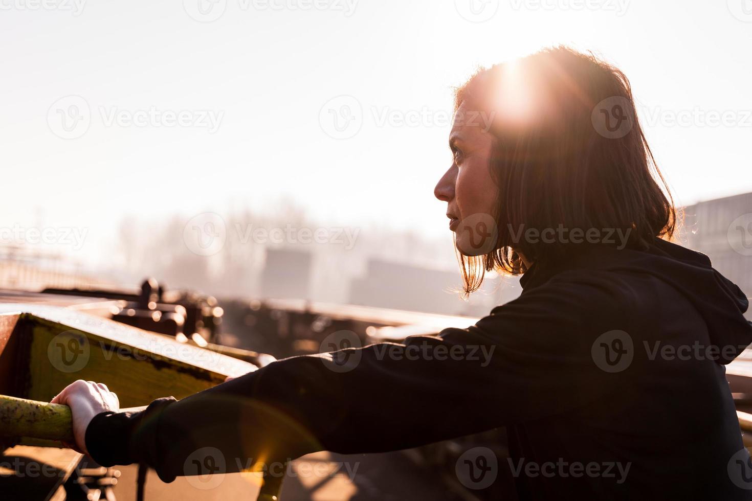 Jeune femelle coureur prend une Pause sur une cargaison train dans le commercial Port dans le Matin photo