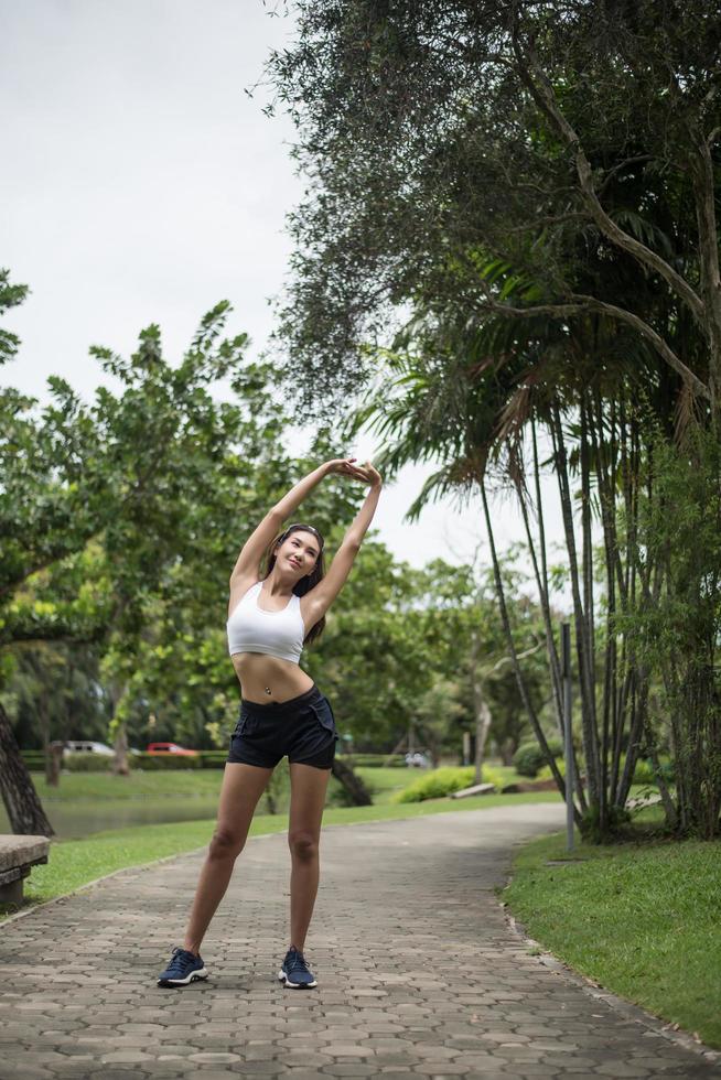 jeune femme sportive qui s'étend dans le parc photo