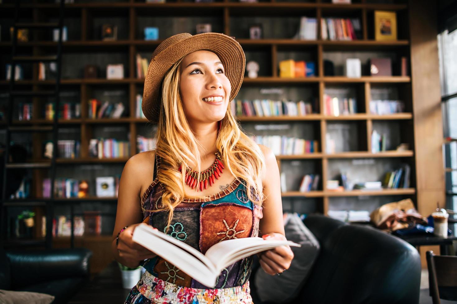 jeune femme lisant un livre dans un café photo