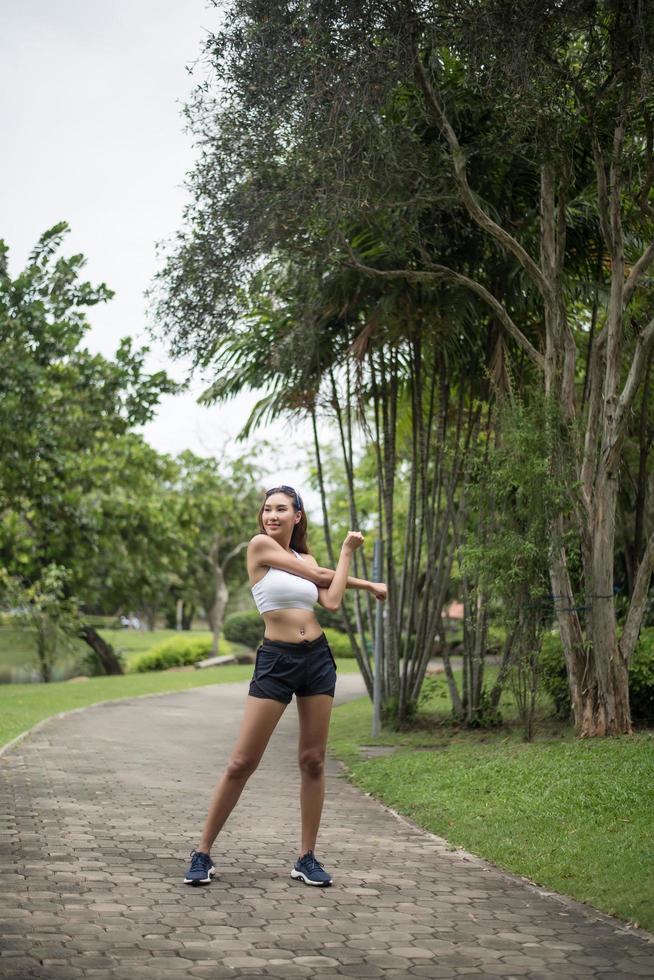 jeune femme sportive qui s'étend dans le parc photo